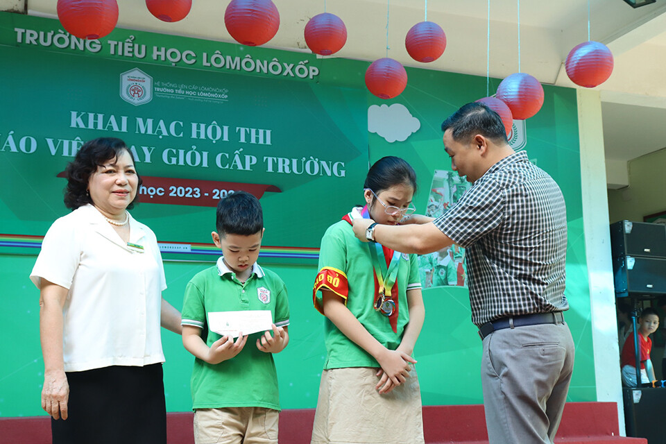Ông Đỗ Trí Dũng - Chủ tịch Hội đồng trường trao Huy chương vàng môn bơi Giải bơi Shin bridge cho học sinh Bùi Phương Kim